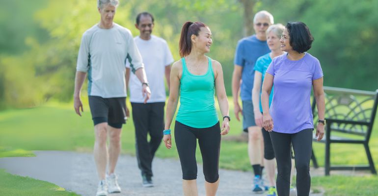 Group of six people walking on a path outside