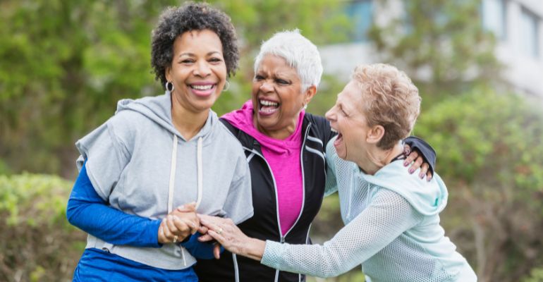 Three women laughing and hugging