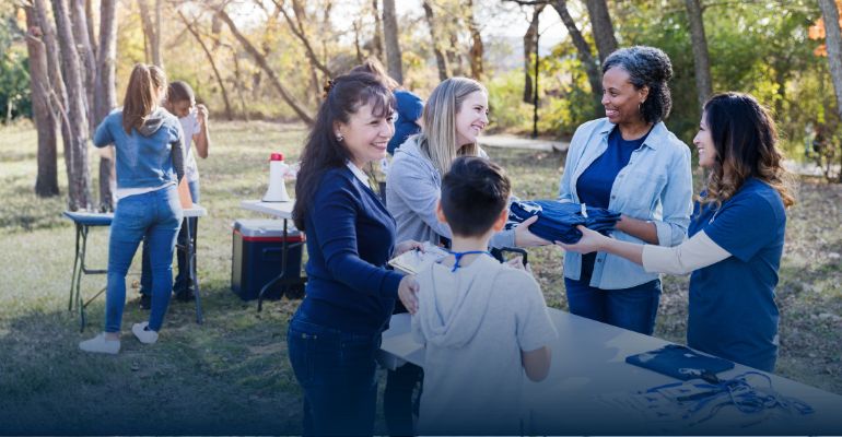 volunteers handing out shirts to other volunteers