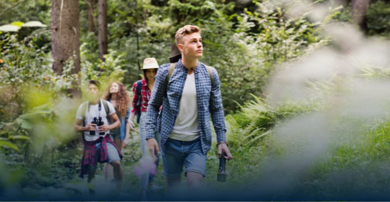 Young man walking in the woods with a backpack
