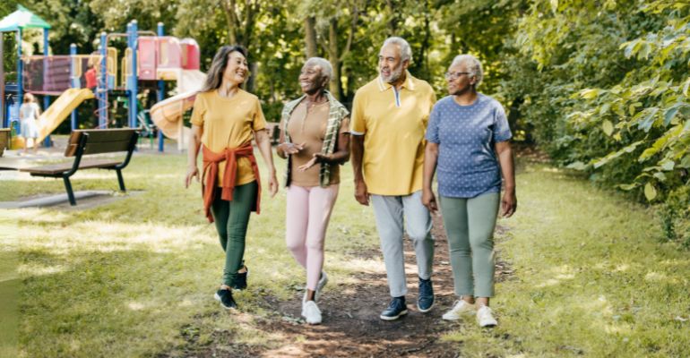 Four people walking on a path in a park