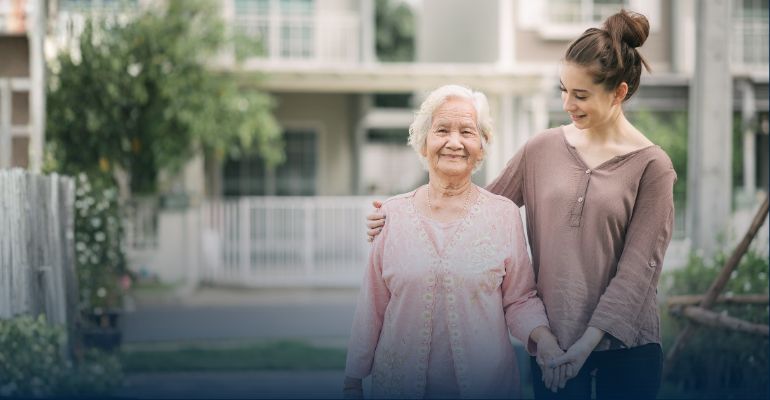 Young women helping older women walk outside