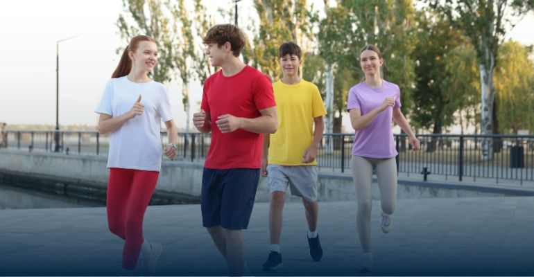 A group of 4 teenagers running in the park